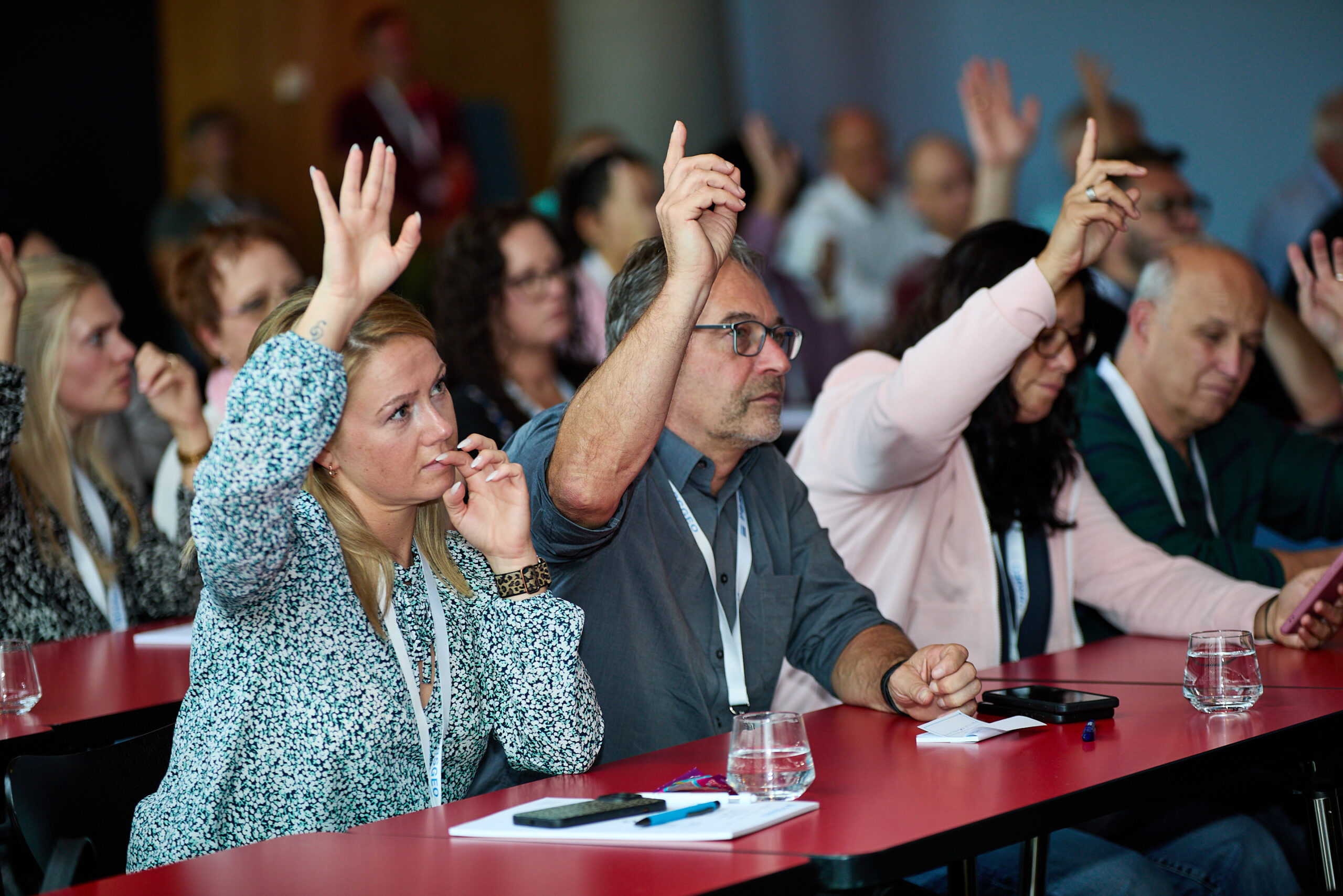 Eventfotografie Symposium Handzeichen bei Umfrage