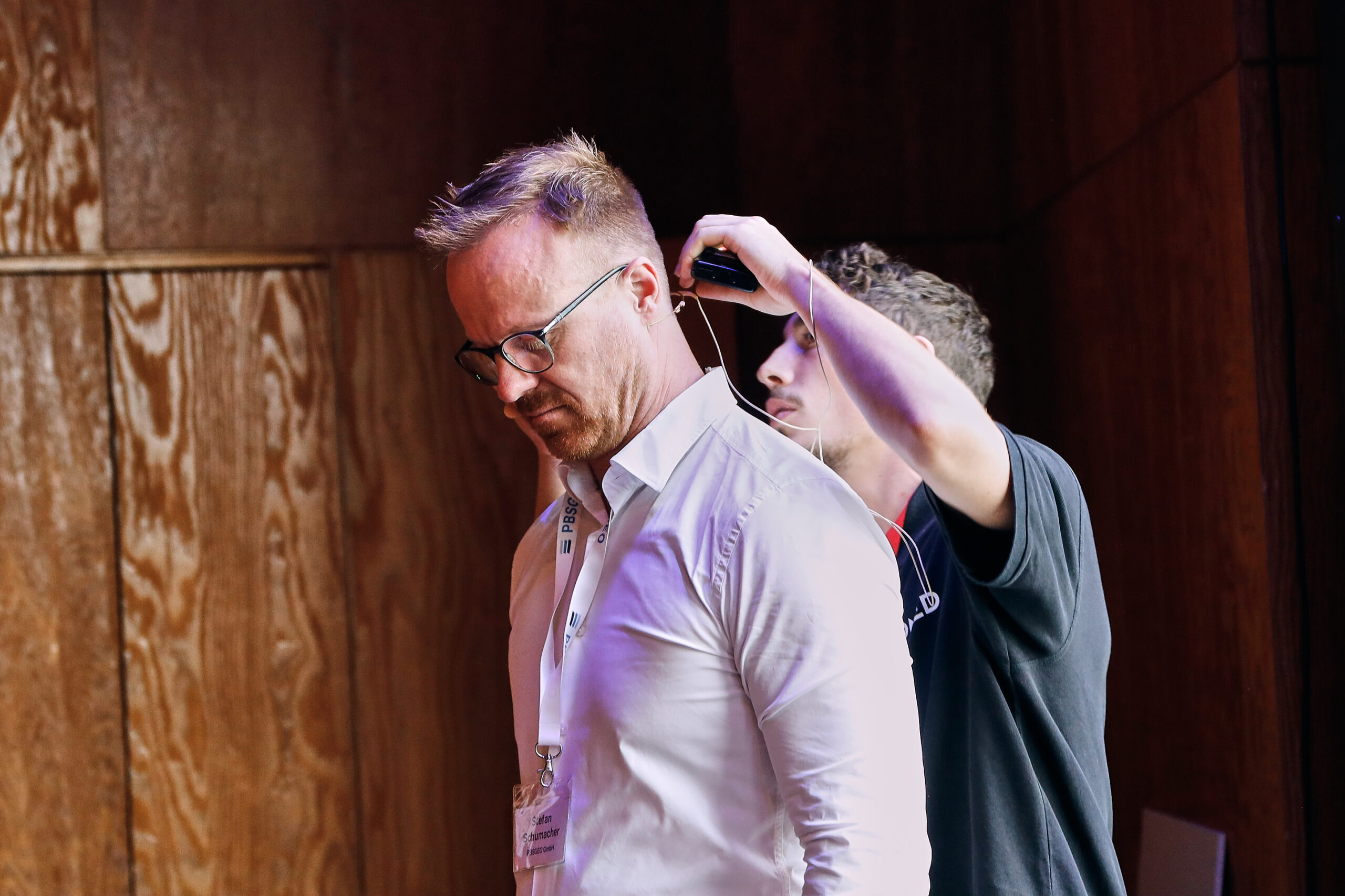Eventfotografie Symposium Referent wird mit Mikrofon ausgestattet