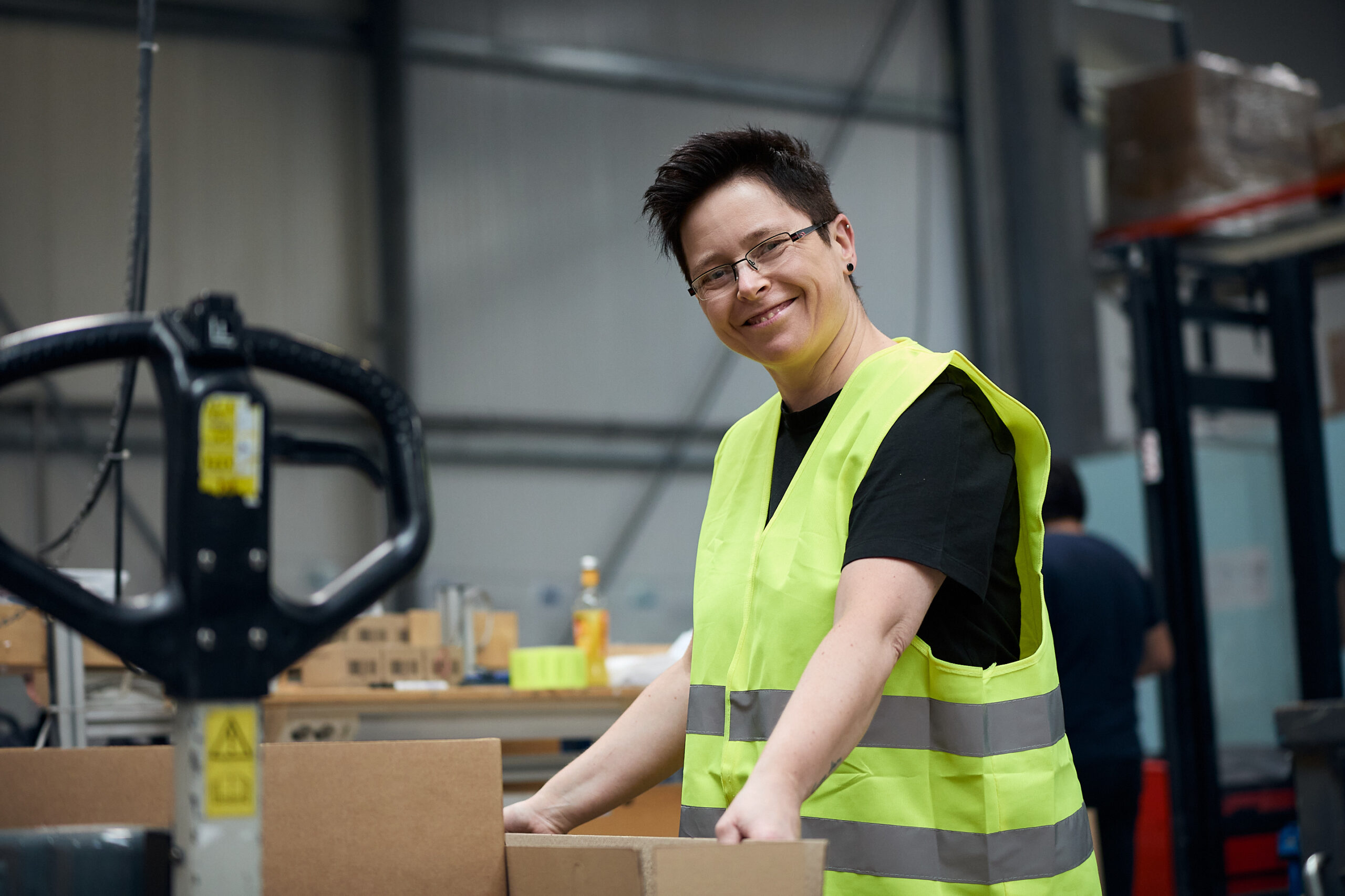 Unternehmensfotografie Frau beim Verpacken von Bauteilen
