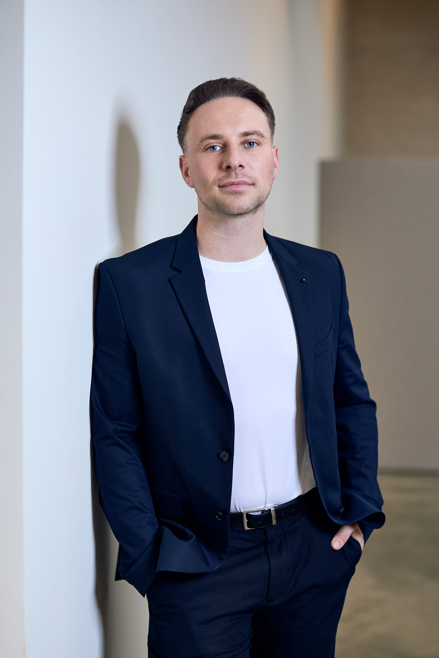 Business Portrait Mann in Dunkelblauem Anzeig lässig an Wand gelehnt
