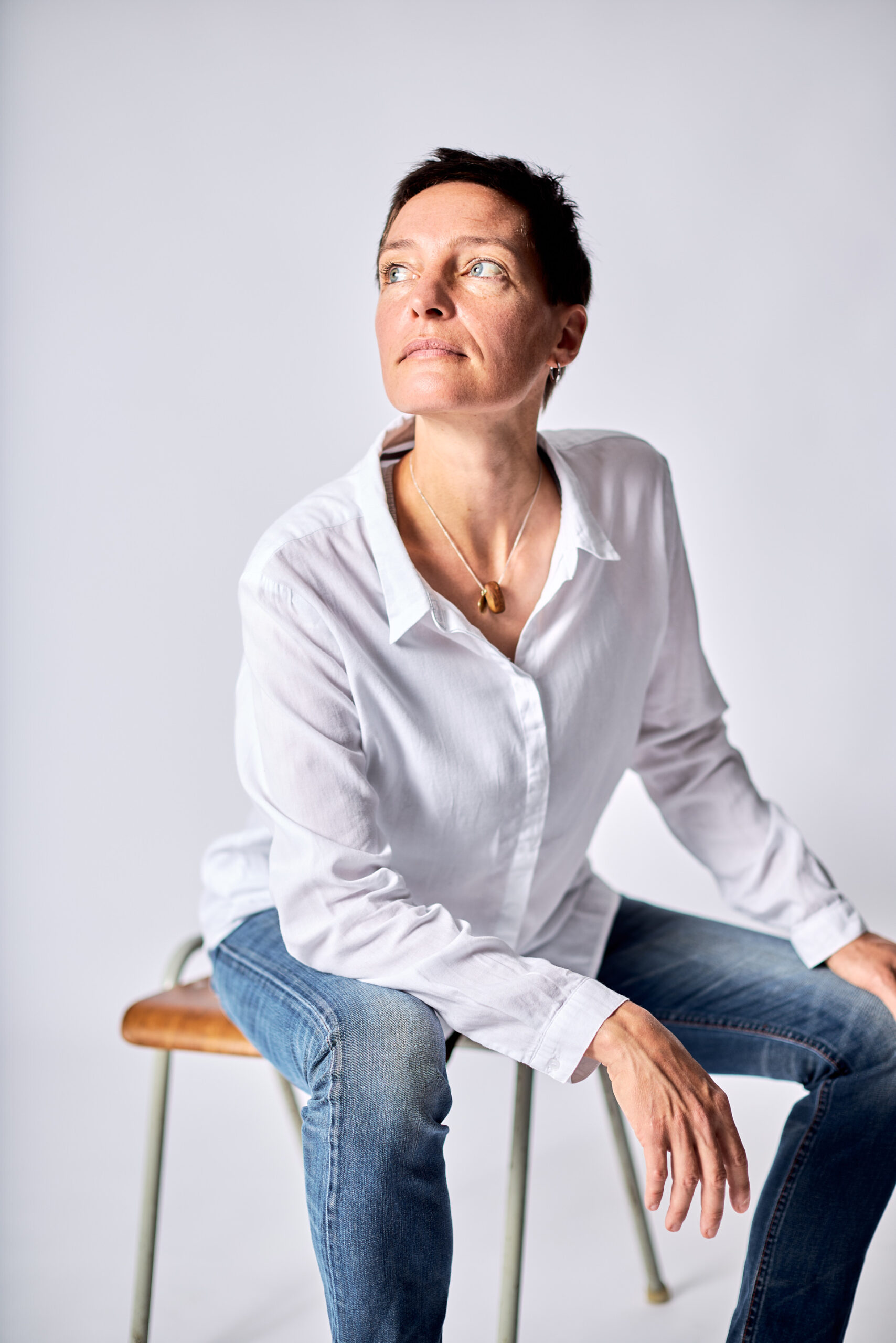 Portrait Frau sitzend in Jeans und weißer Bluse