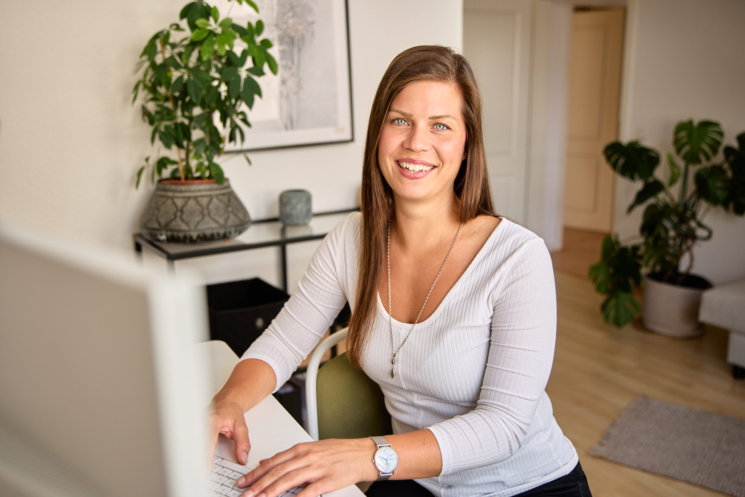 Portraitshooting – Am Schreibtisch mit Laptop, lächelnd