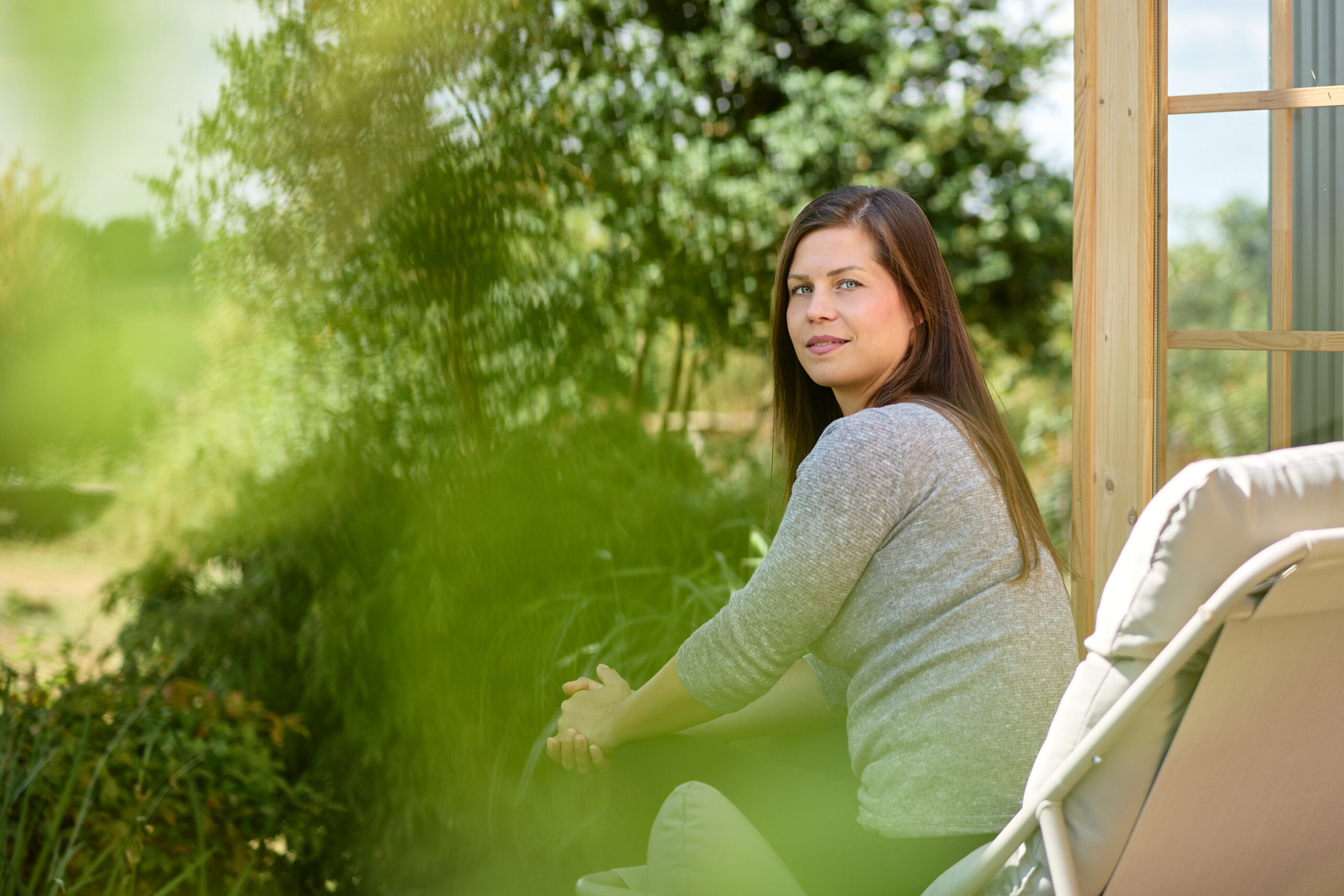 Portraitshooting – Sitzend im Garten vor Terrassentür, im Grünen
