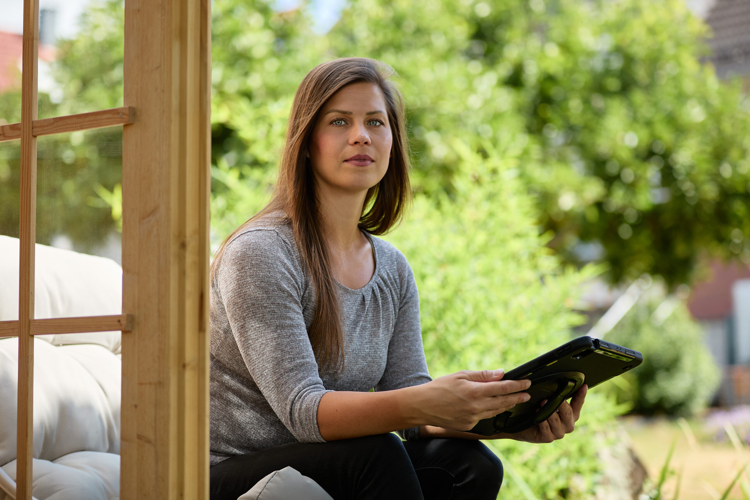 Portraitshooting – Sitzend im Garten mit Tablet in der Hand