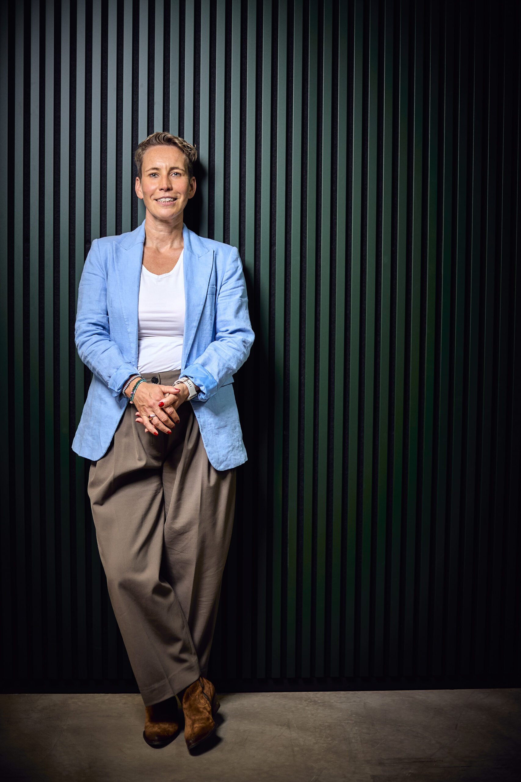 Coaching-Shooting – Ganzkörperportrait, an dunkle Wand gelehnt