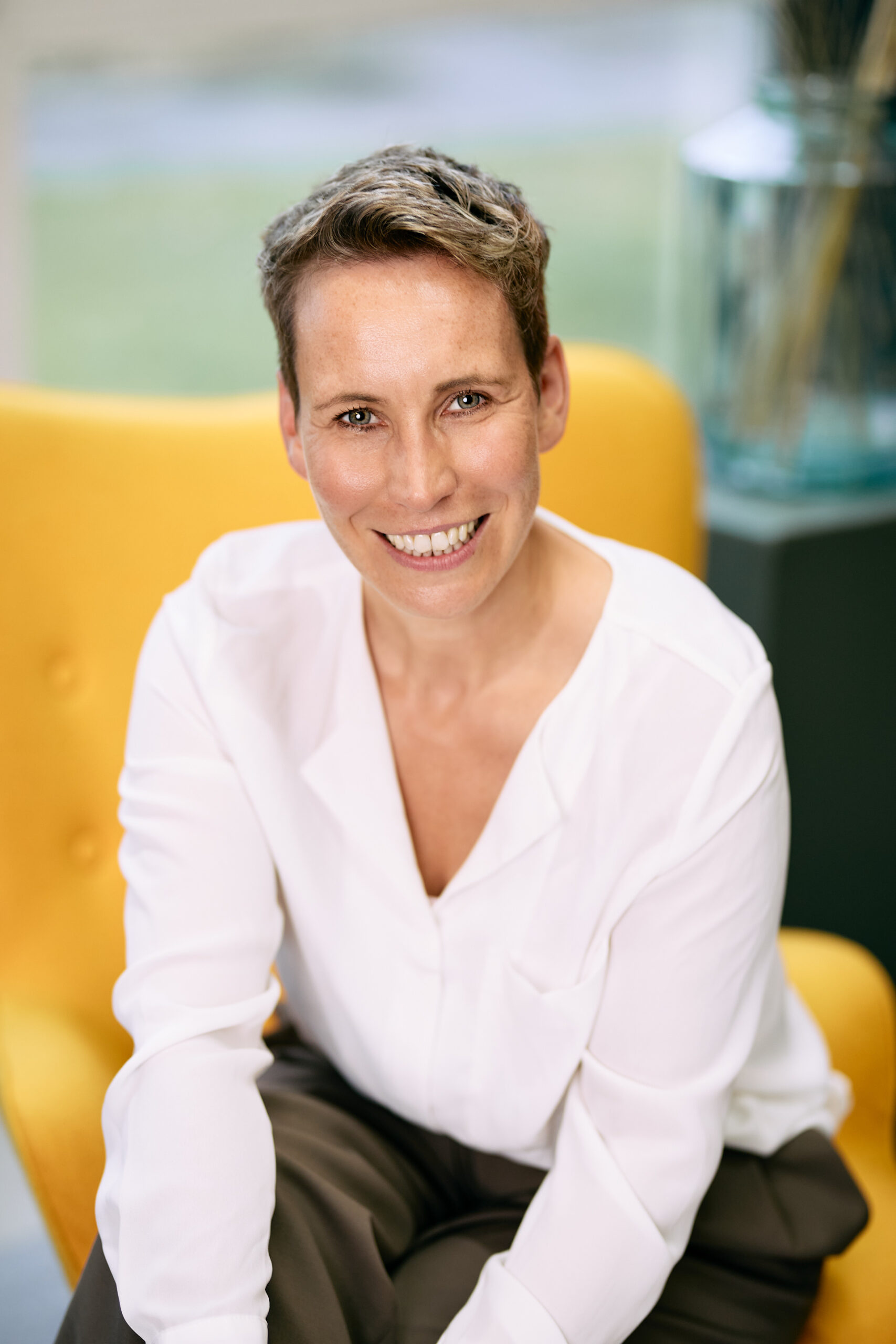 Coaching-Shooting – Nahportrait, lächelnd, im gelben Sessel