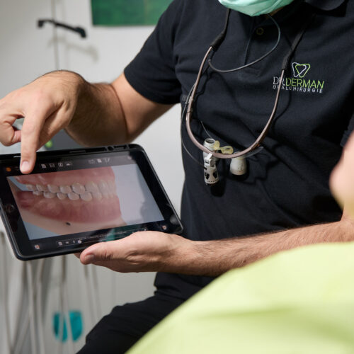 Zahnarzt erklärt Patientin am Tablet Behandlung