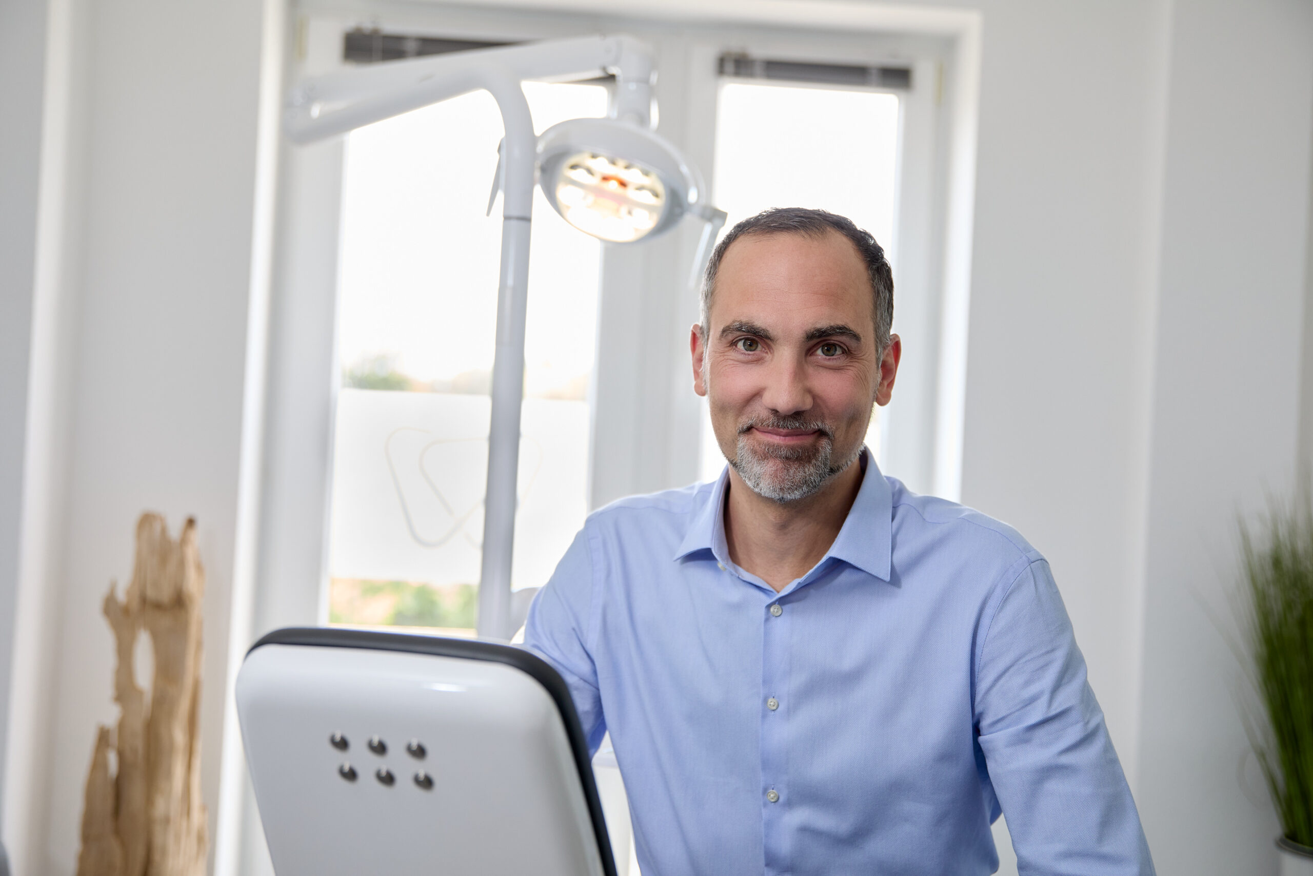 Oralchirurgie Dr. Derman – Portrait des Zahnarztes am Behandlungsstuhl"